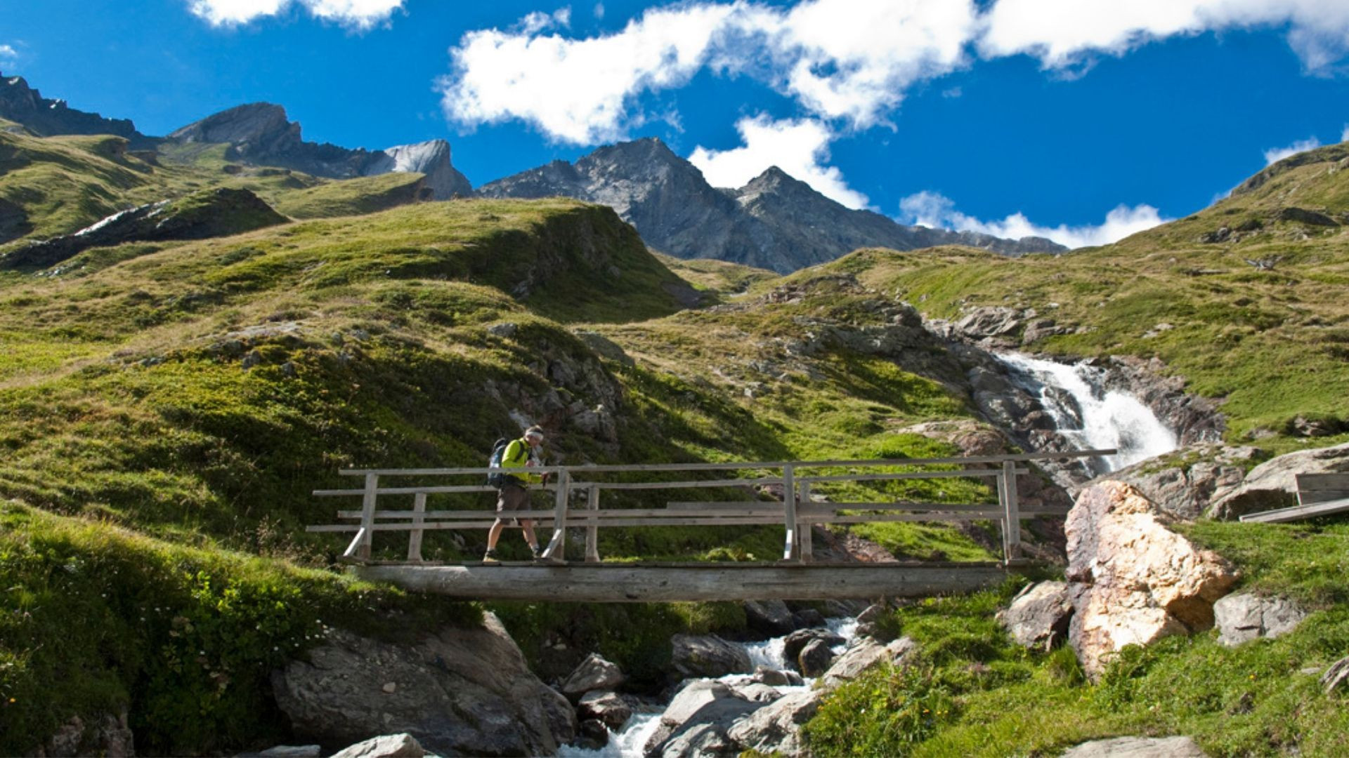 Randonneurs sur une passerelle près d'une cascade - Tour du Mont-Blanc - Haute-Savoie - France