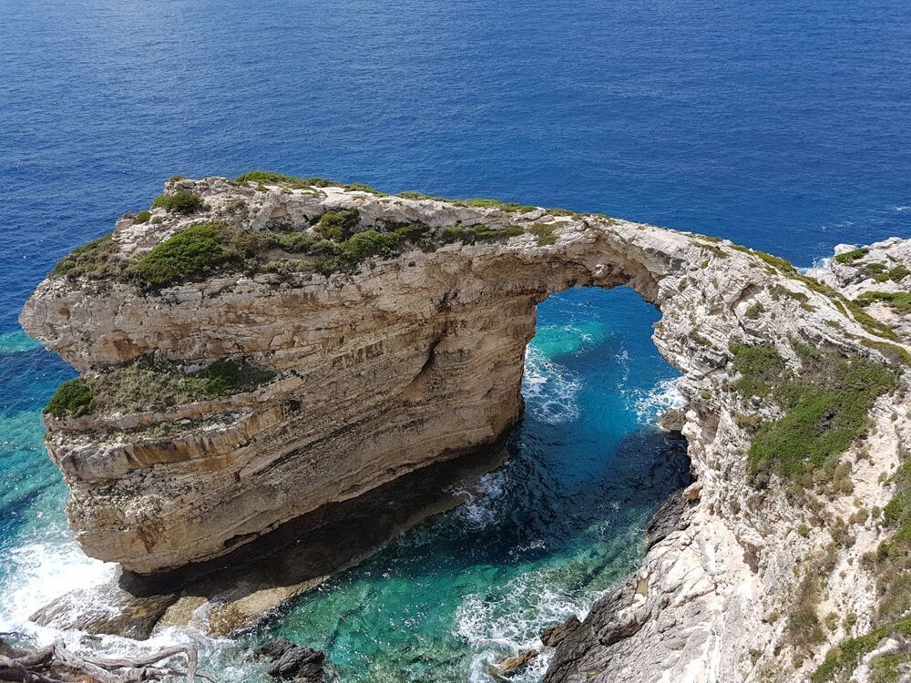 The natural Tripitos arch on the coast of Paxos