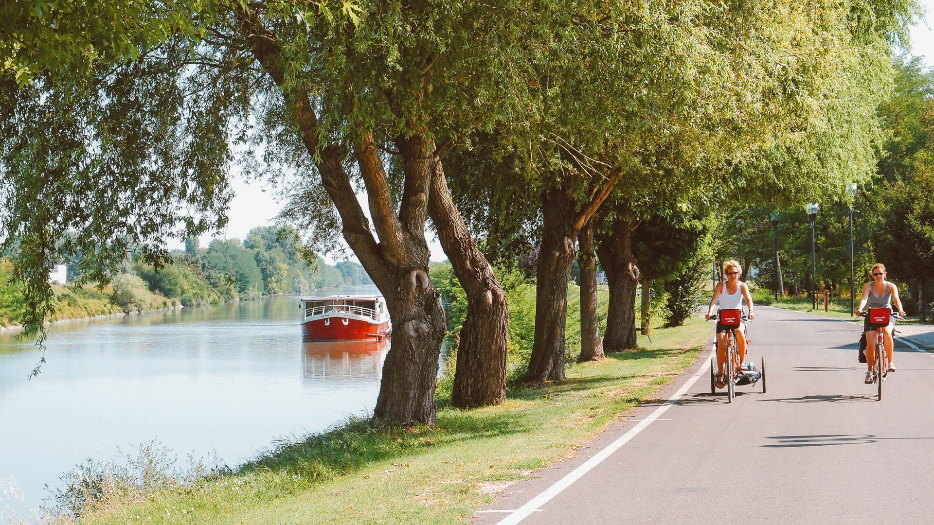 Cyclistes le long du fleuve et péniche-hôtel - Vénétie - Italie