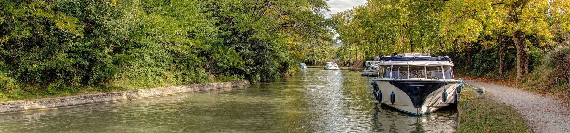Bateau amarré sur le Canal du Midi bordé d'arbres - Occitanie - France