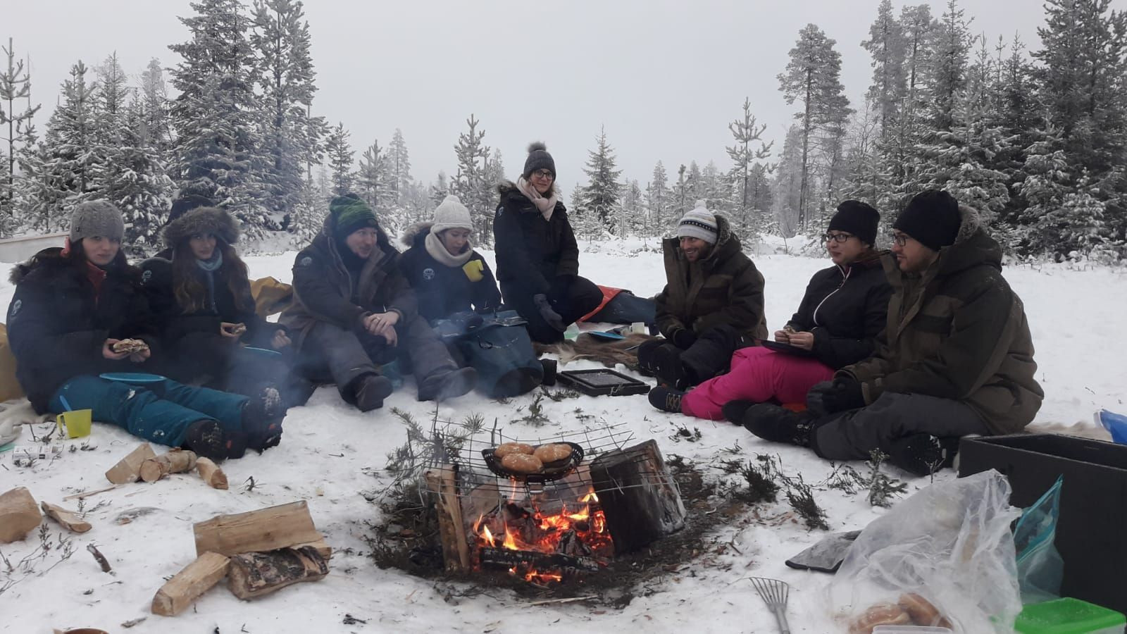 Pause autour du feu dans la forêt enneigée - Laponie - Finlande