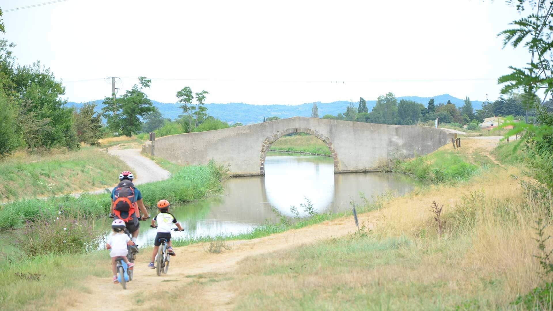 © Géraldine Vanaker Famille à vélo vers le pont de Jouarres - Canal du Midi - France