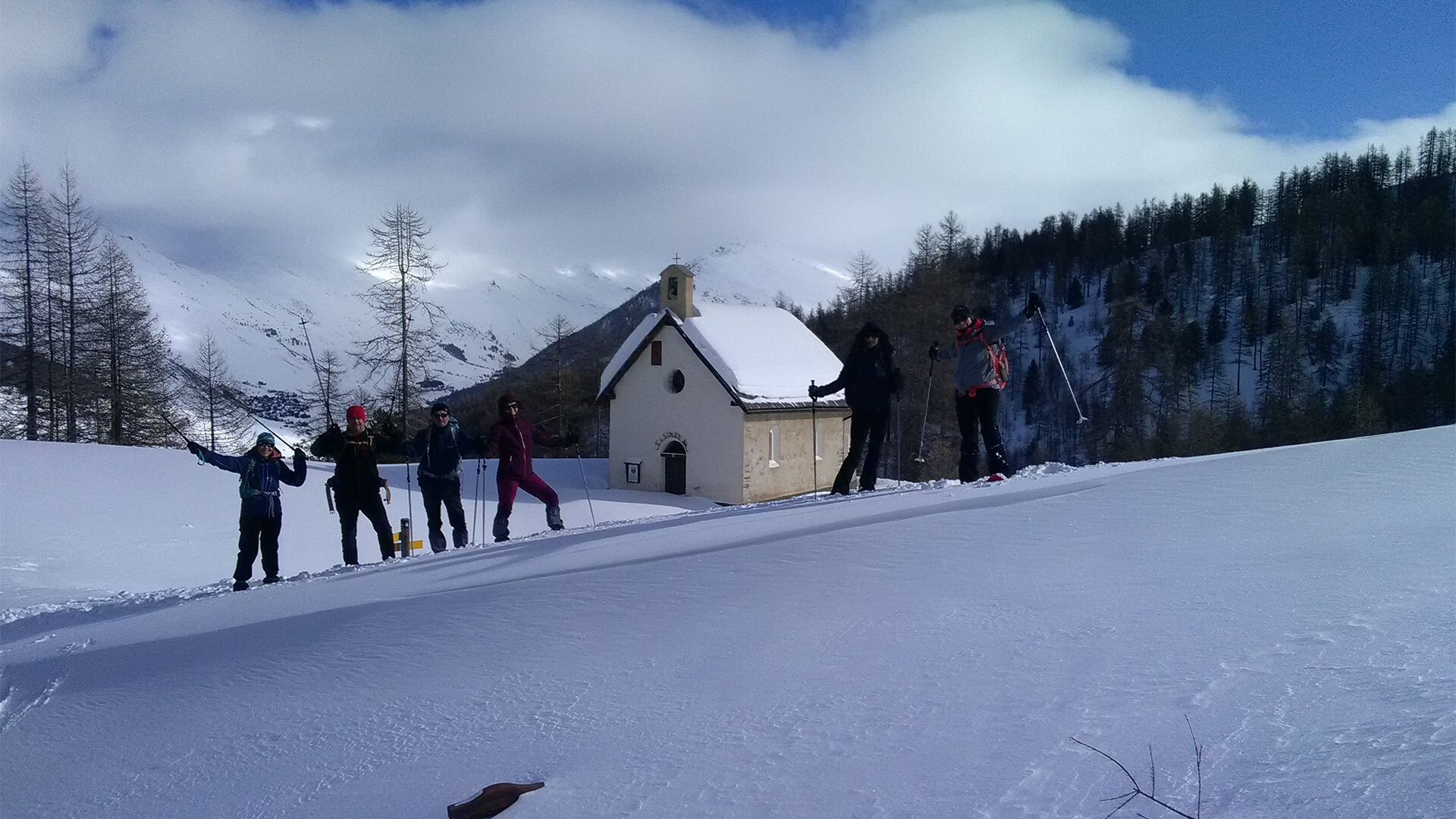 Randonneurs en raquettes près d'une chapelle enneigée - Queyras - Hautes-Alpes, France