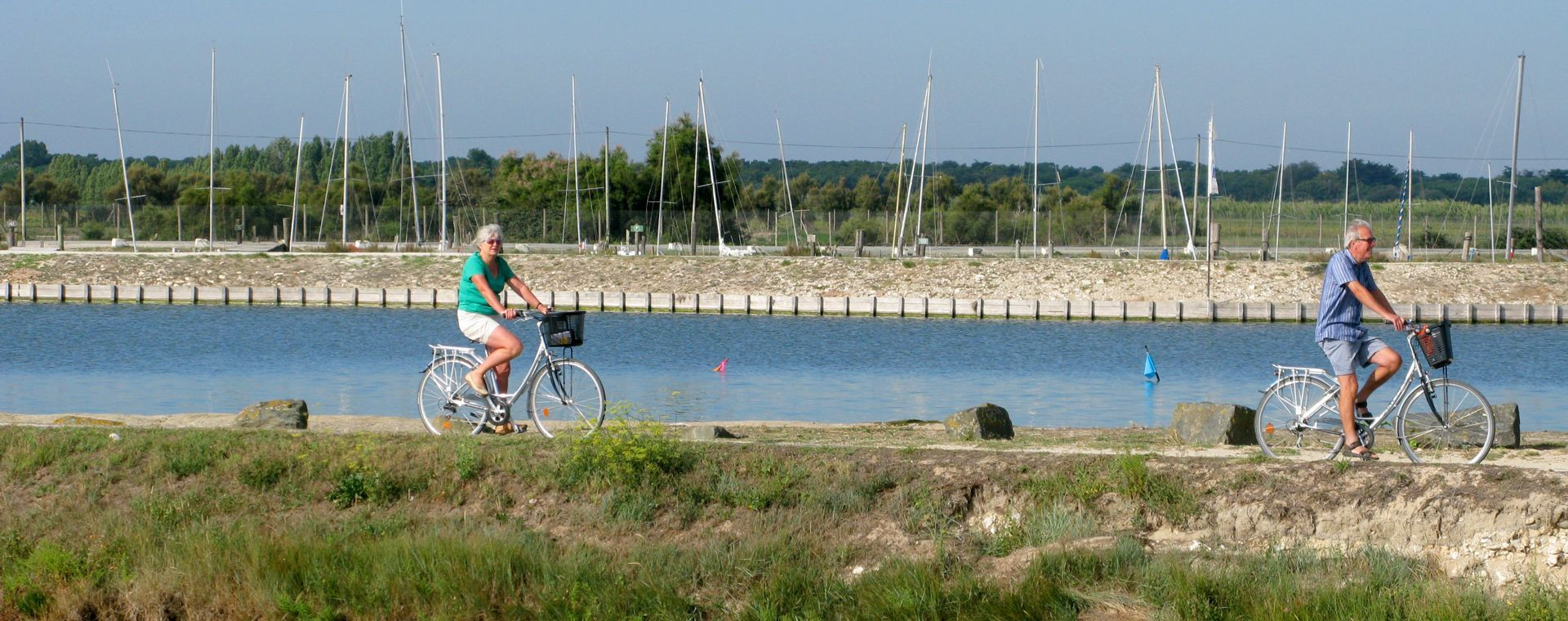 Couple de cyclistes le long d'un port - Île de Ré - France