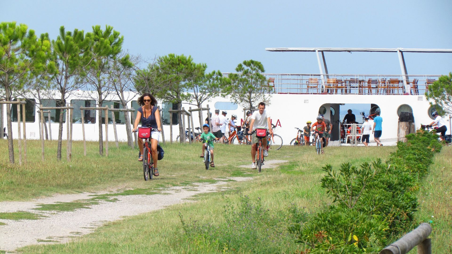 Cyclistes sur la piste près d'un bateau - Lagune de Venise - Italie