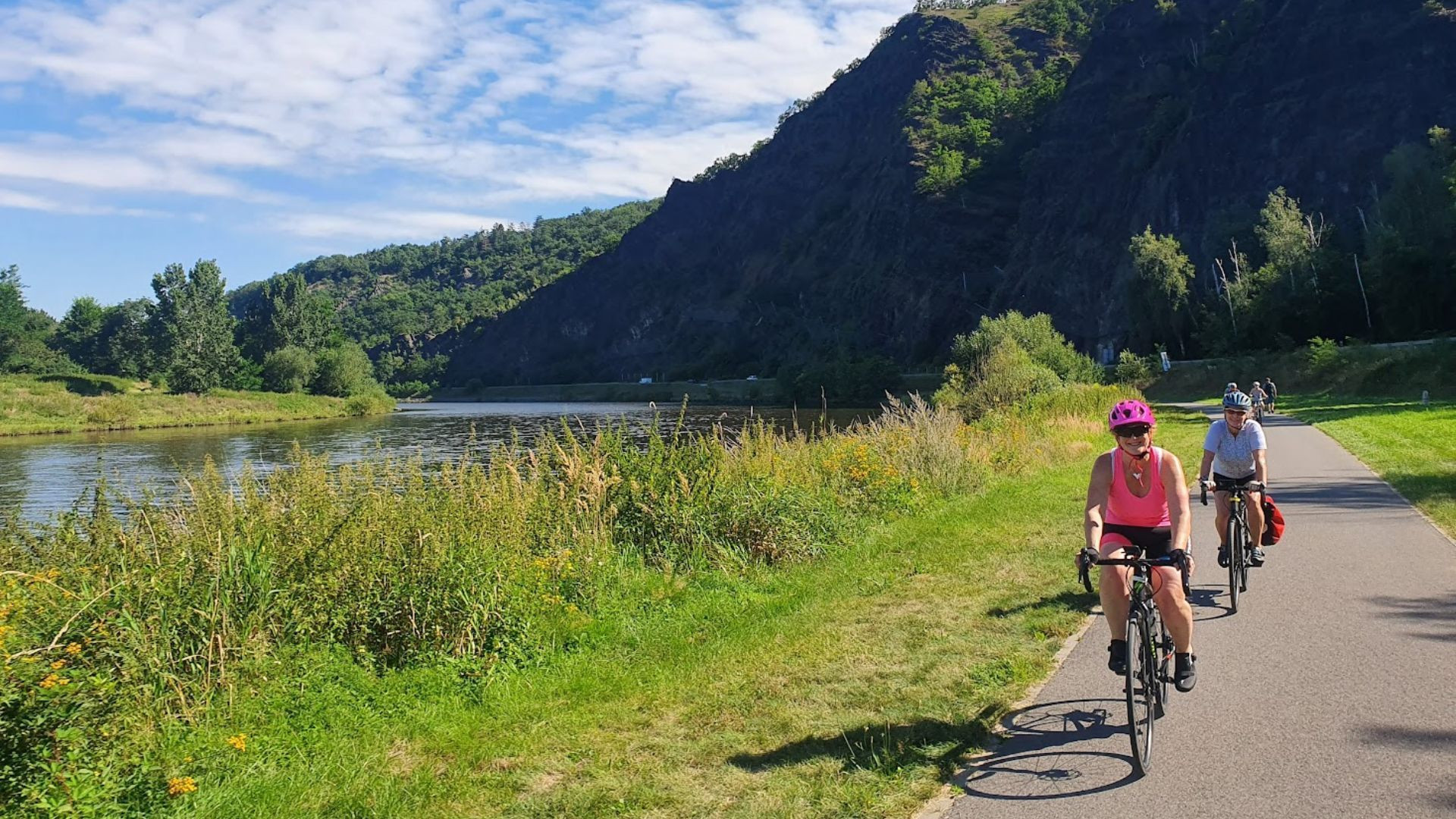 Cyclistes sur une piste au bord de la rivière sous des falaises rocheuses - République tchèque