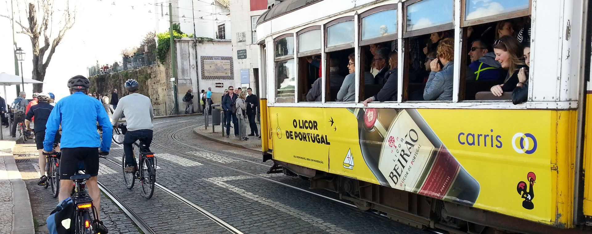 Cyclistes et tramway jaune en ville - Lisbonne - Portugal