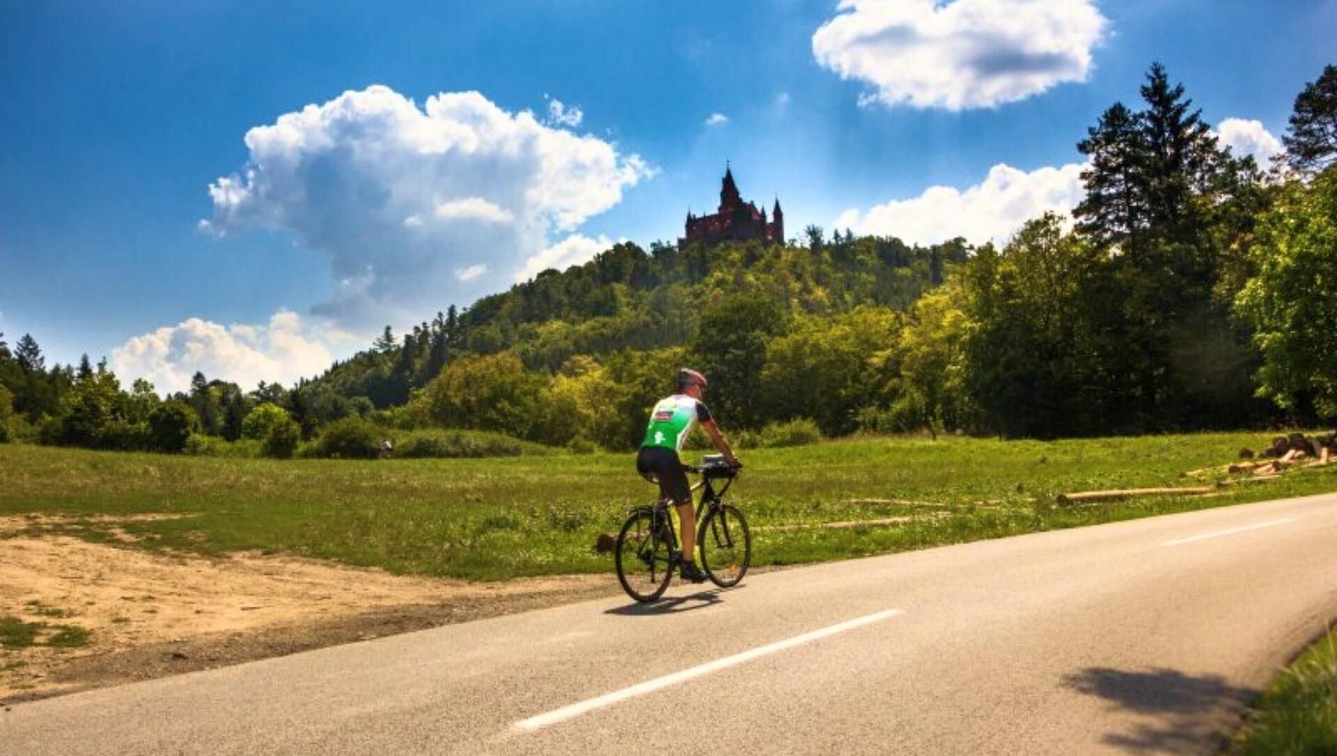 Cycliste sur une route de campagne au pied du château perché de Pecka - République tchèque