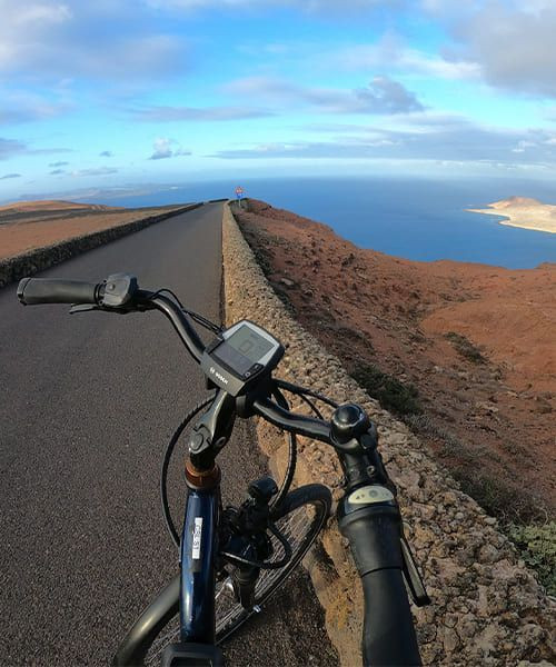 Cycliste sur les routes volcaniques de Lanzarote surplombant la mer - Canaries - Espagne