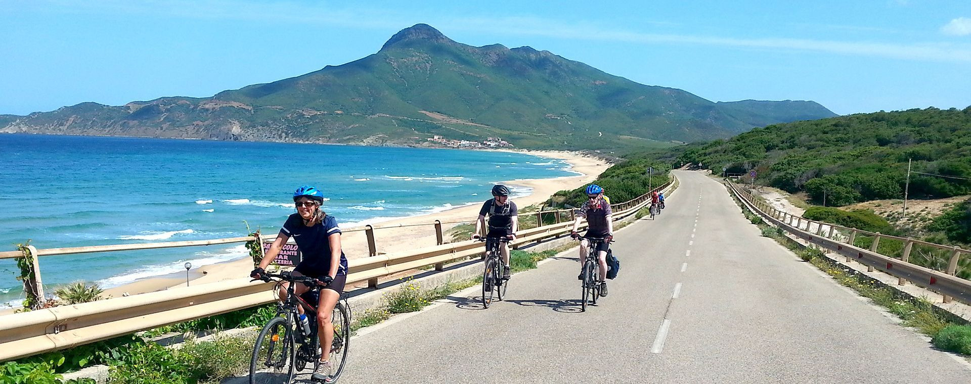 Cyclistes sur la route côtière face à la plage - côte ouest - Sardaigne, Italie