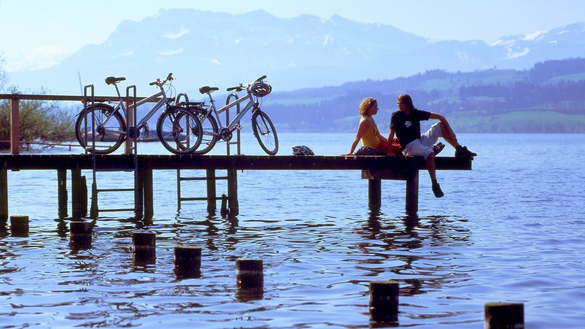 Cyclistes au repos sur un ponton du lac des Quatre-Cantons - Suisse