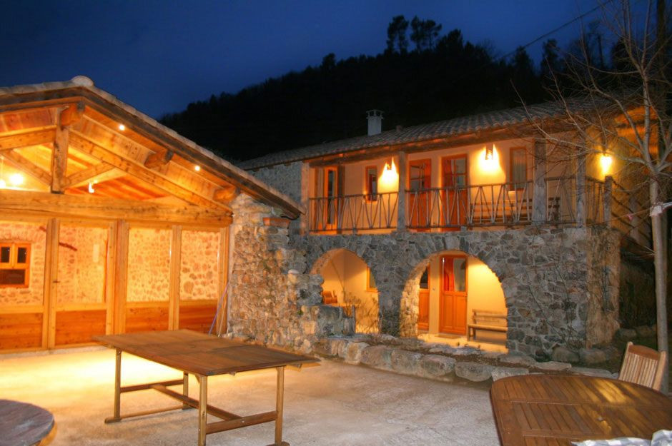 Gîte en pierre et terrasse illuminés à la tombée de la nuit - France