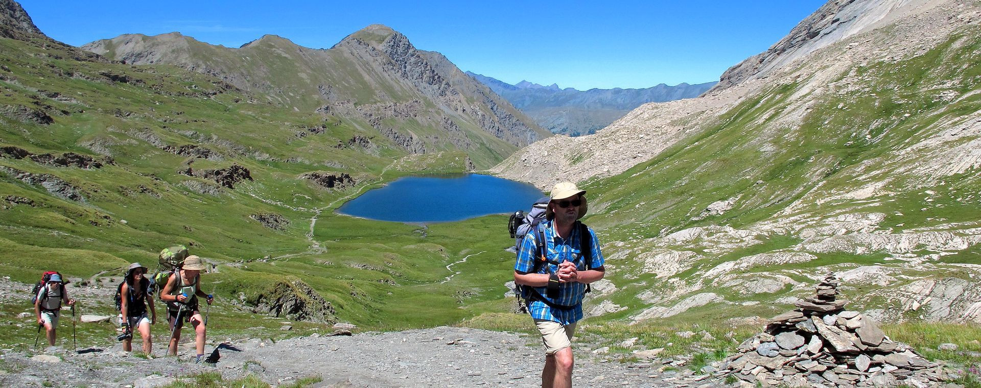 Randonneurs sur la Grande Traversée des Alpes près d'un lac d'altitude - Alpes - France