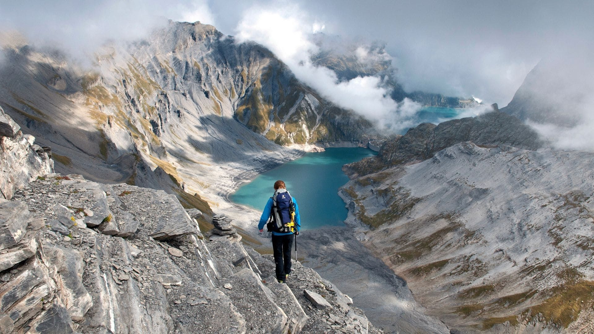 Randonneur descendant vers un lac turquoise - Massif du Grenairon - Alpes - France