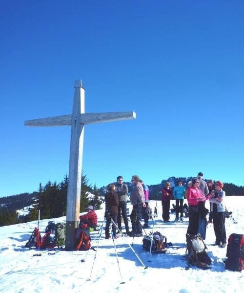 Groupe à la croix d'un sommet enneigé - Alpes