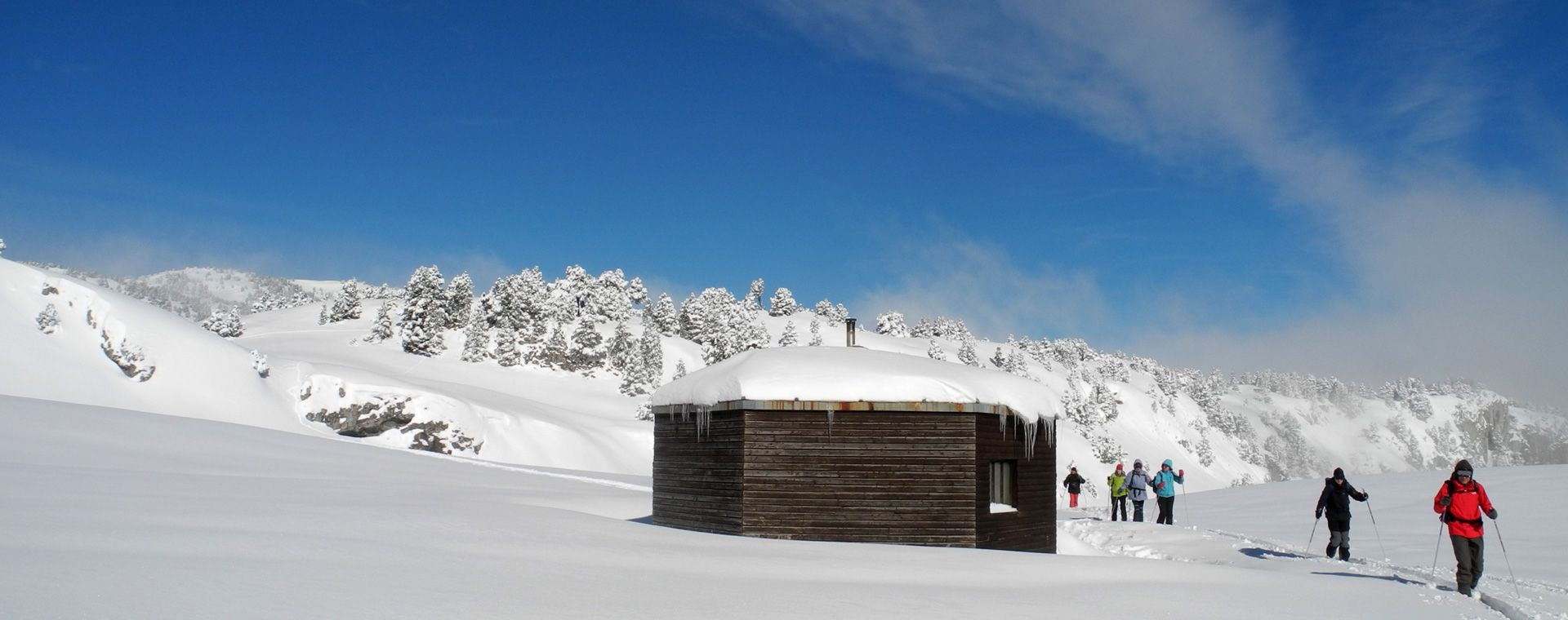 Groupe en ski de randonnée nordique près d'une cabane enneigée - Vercors - France