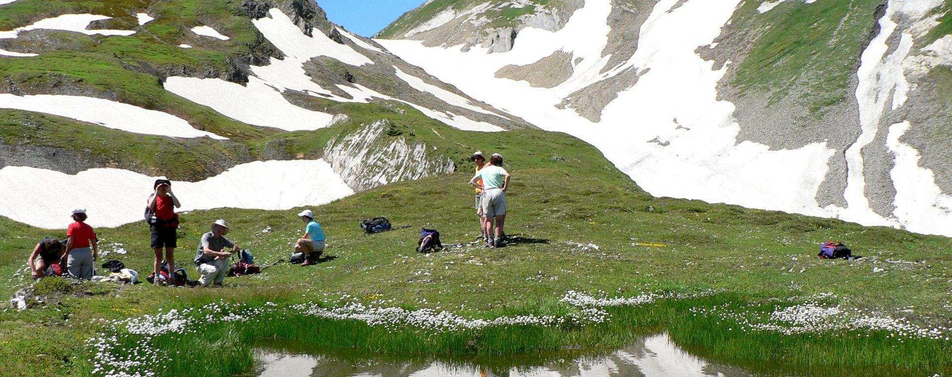 Randonneurs en pause près d'un névé en alpage - Grande Traversée des Alpes - Alpes du Nord - France