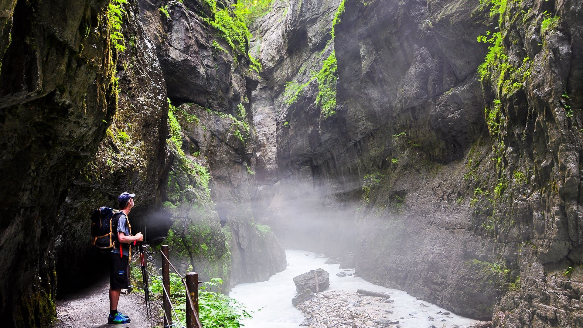 Randonneur le long de la rivière dans la gorge brumeuse - Gorges de la Partnach - Bavière, Allemagne