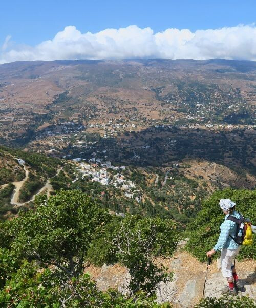 © François Ribard Randonneuse descendant du monastère Panachrantou avec vue sur les villages - Andros - Grèce