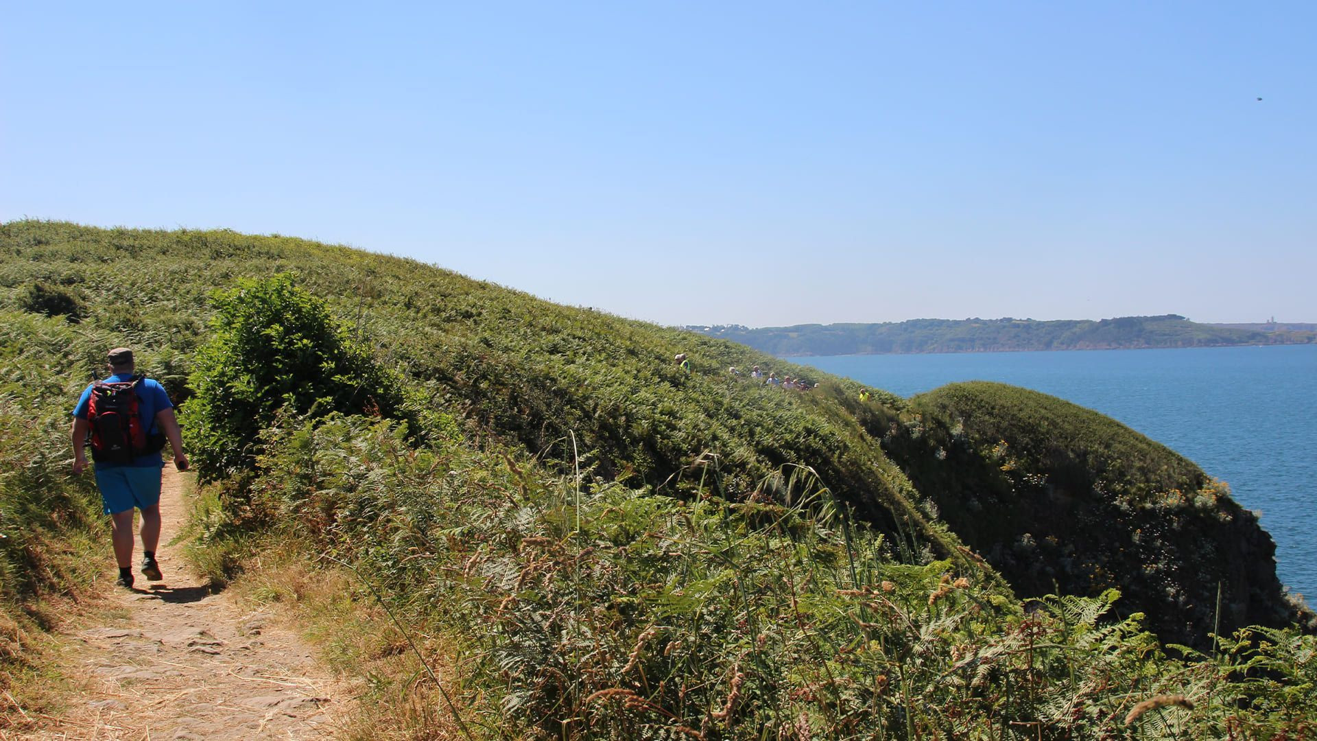 Randonneur sur un sentier côtier au-dessus de la mer - Bretagne - France