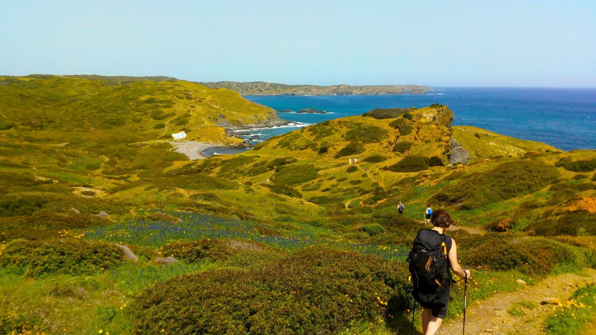 Randonneuse sur un sentier côtier au-dessus d'une crique méditerranéenne