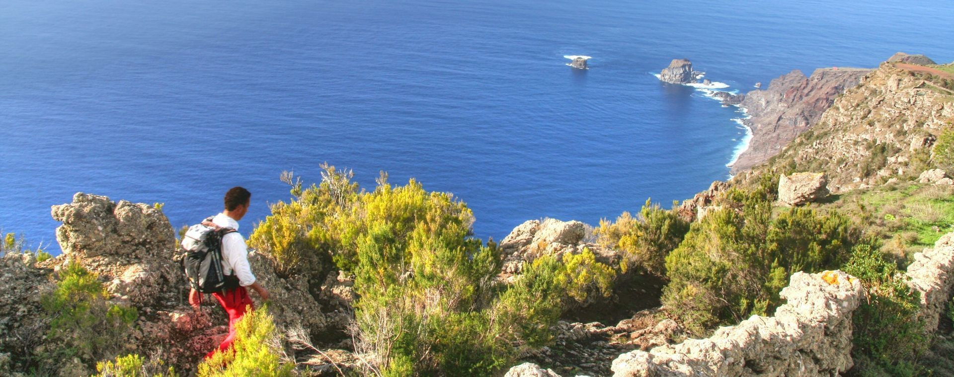 Randonneuse sur la crête côtière face aux Roques de Salmor - El Hierro - Îles Canaries, Espagne