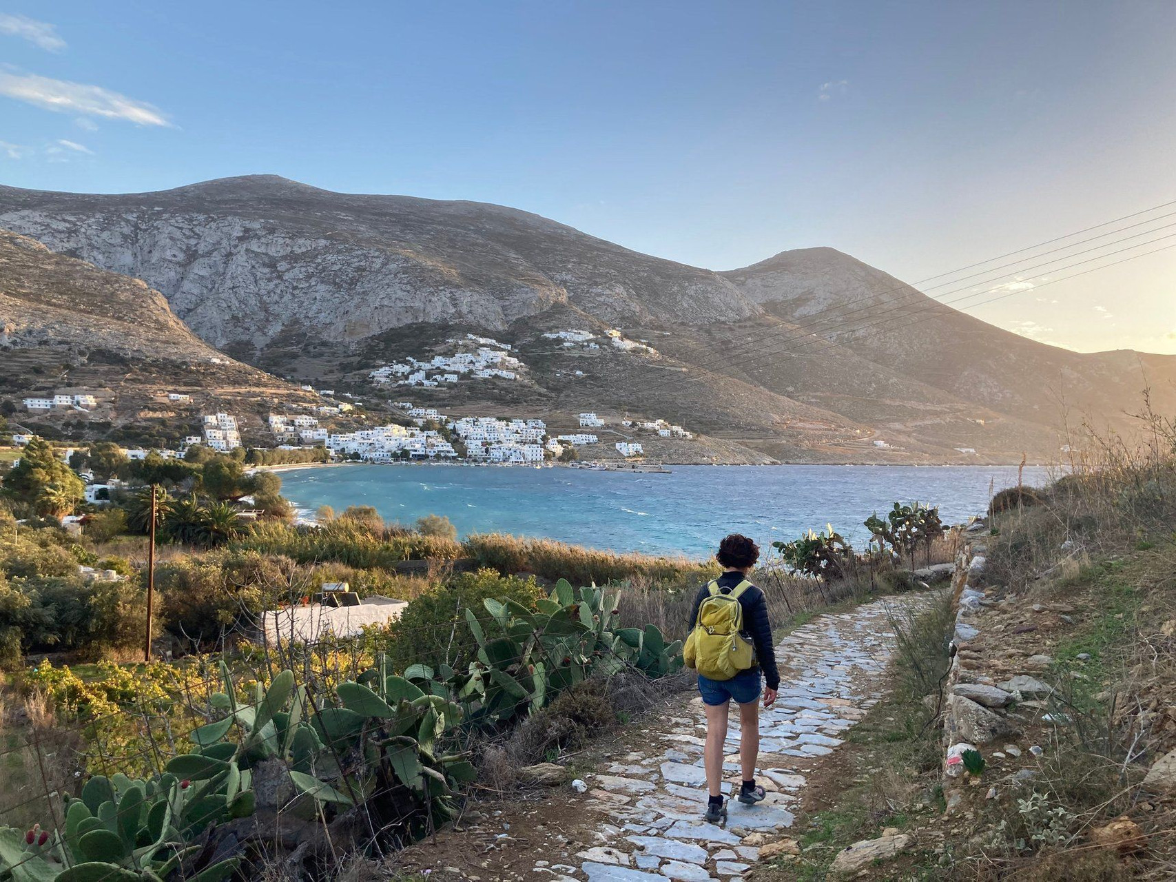 Randonneuse sur le chemin pavé au-dessus de la baie - Amorgos - Cyclades - Grèce