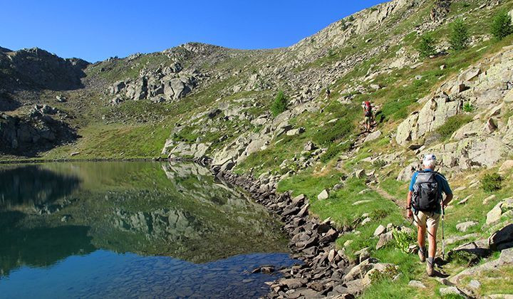 Randonneurs au bord d'un lac de montagne - Grande Traversée des Alpes - France