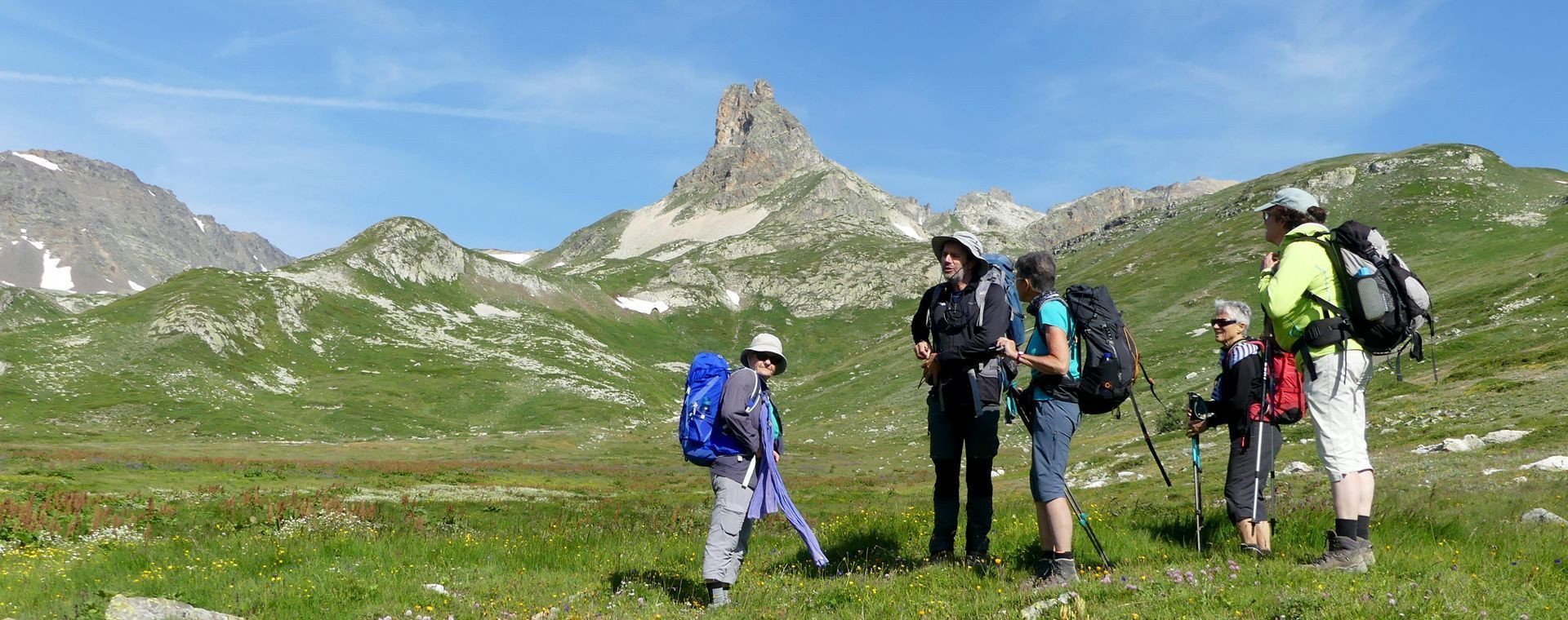 Randonneurs dans un alpage fleuri - Vallée de la Clarée - Écrins, Alpes, France