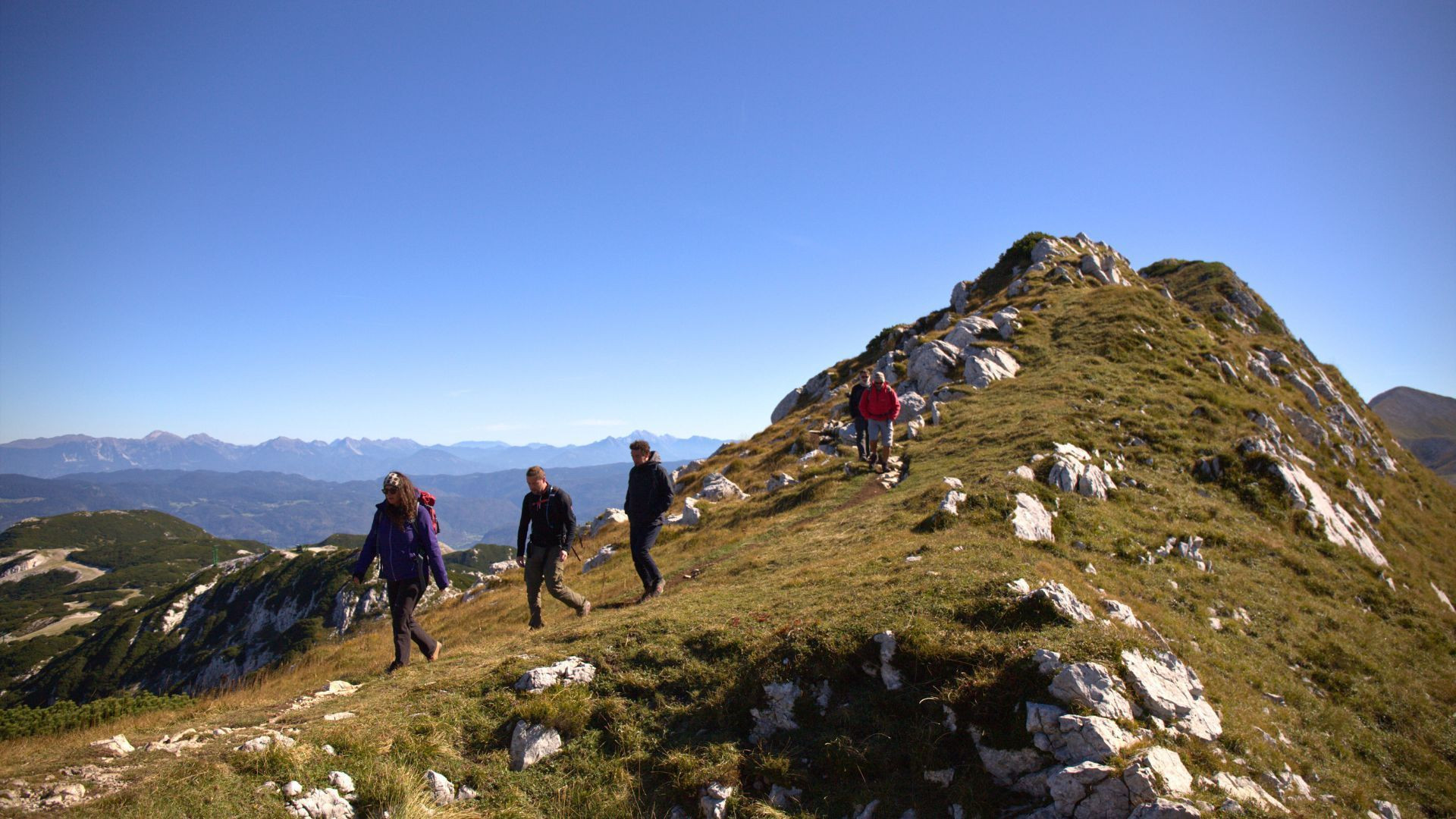 Randonneurs sur une crête herbeuse au sommet - Alpes juliennes - Slovénie