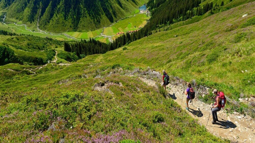 Randonneurs sur un sentier dominant la vallée - Trek de Munich au lac de Côme - Alpes
