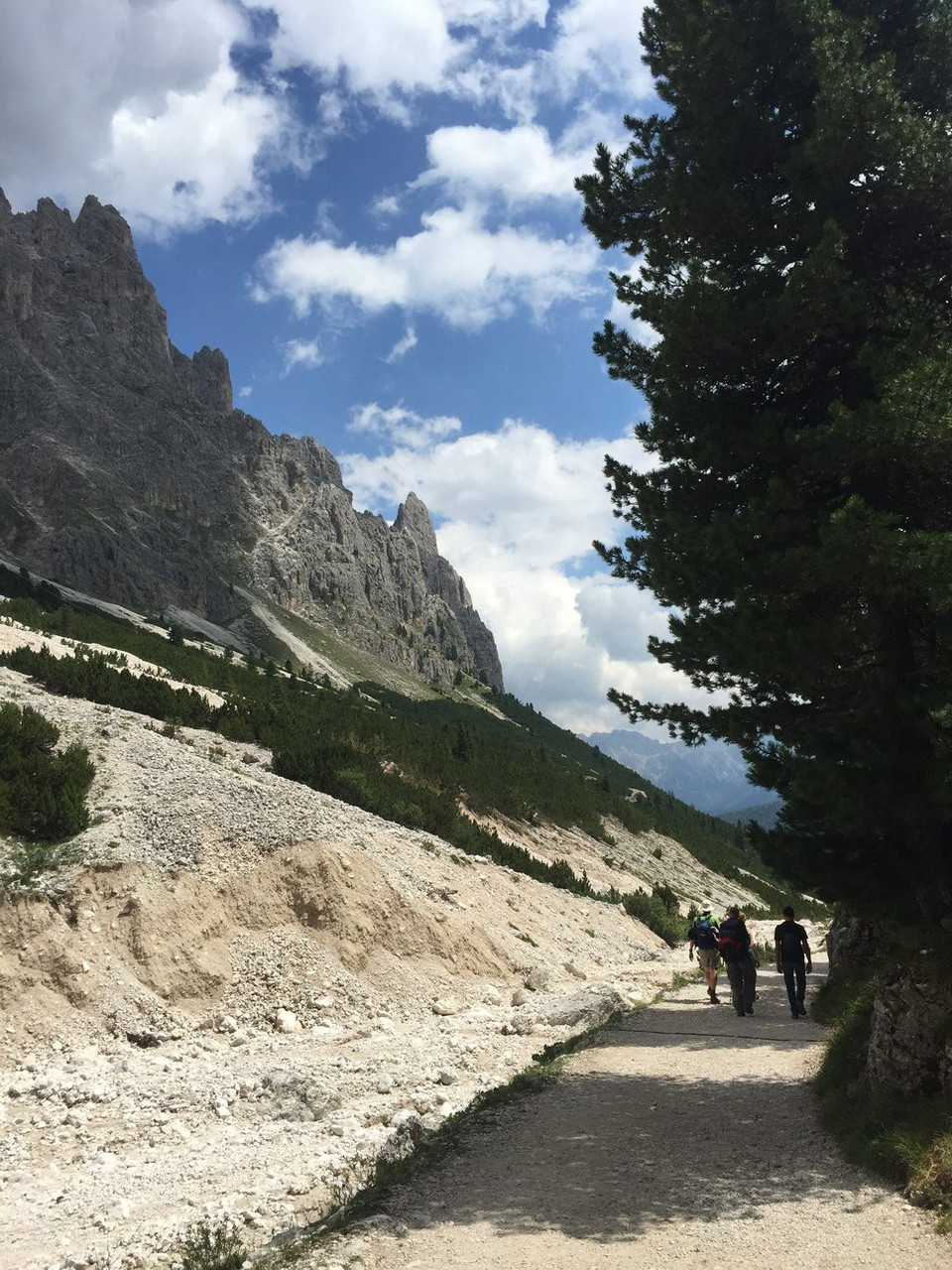 Randonneurs sur un sentier au pied des parois des Dolomites - Italie