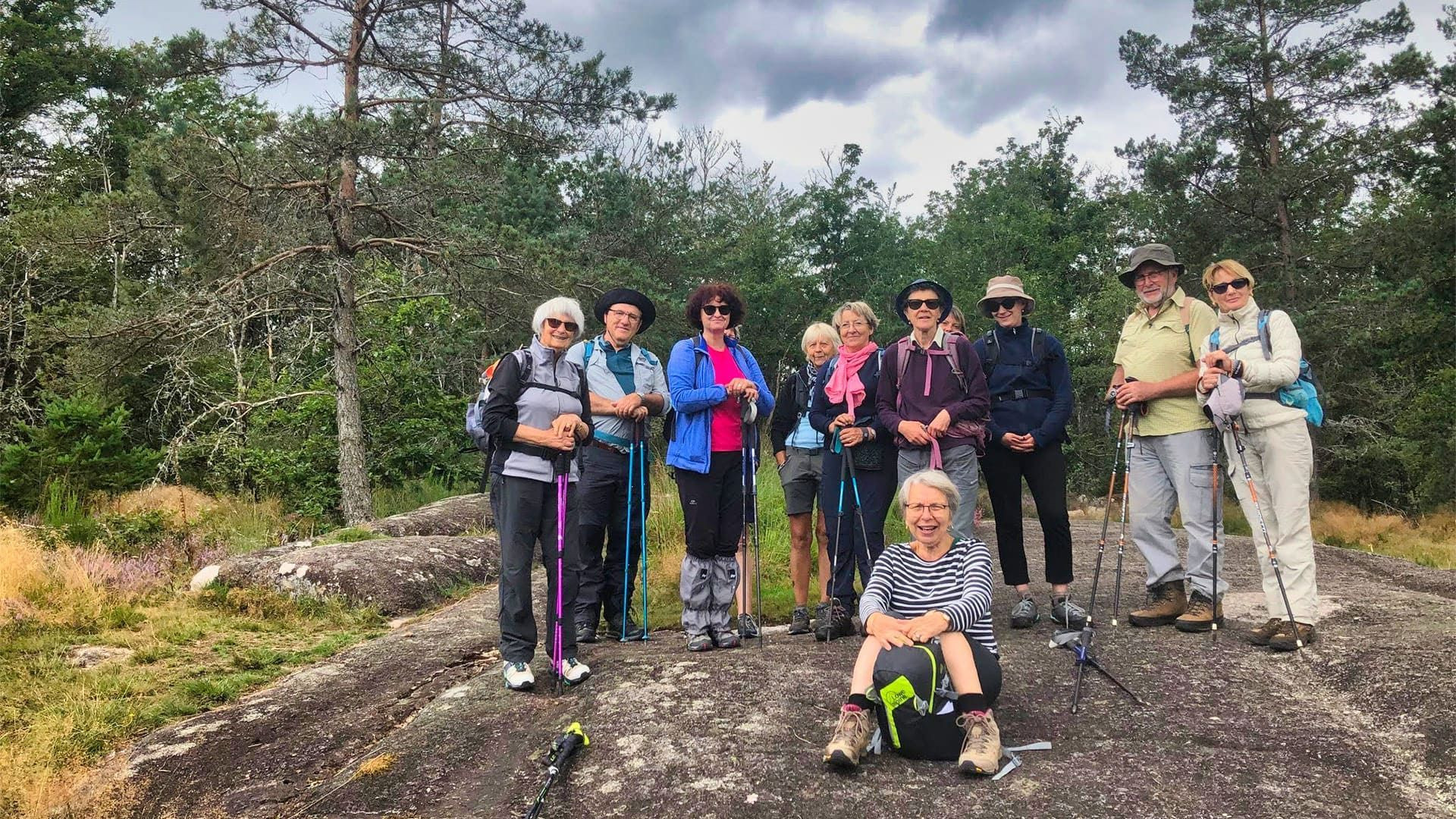 Groupe de randonneurs sur un rocher en forêt - La Grave - France