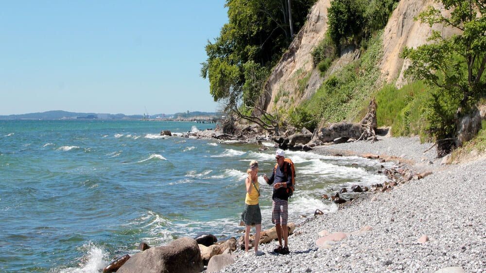 Randonneurs sur la plage de galets au pied des falaises - Île de Rügen - Mer Baltique, Allemagne
