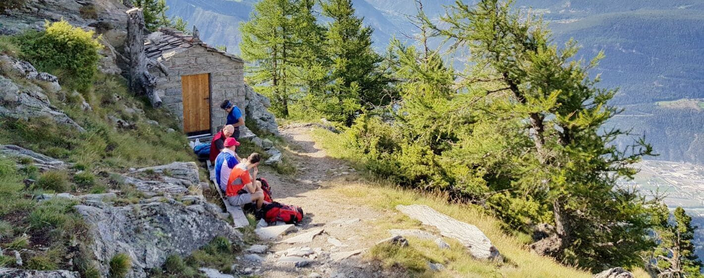Randonneurs en pause près d'un refuge de pierre - Valais - Suisse