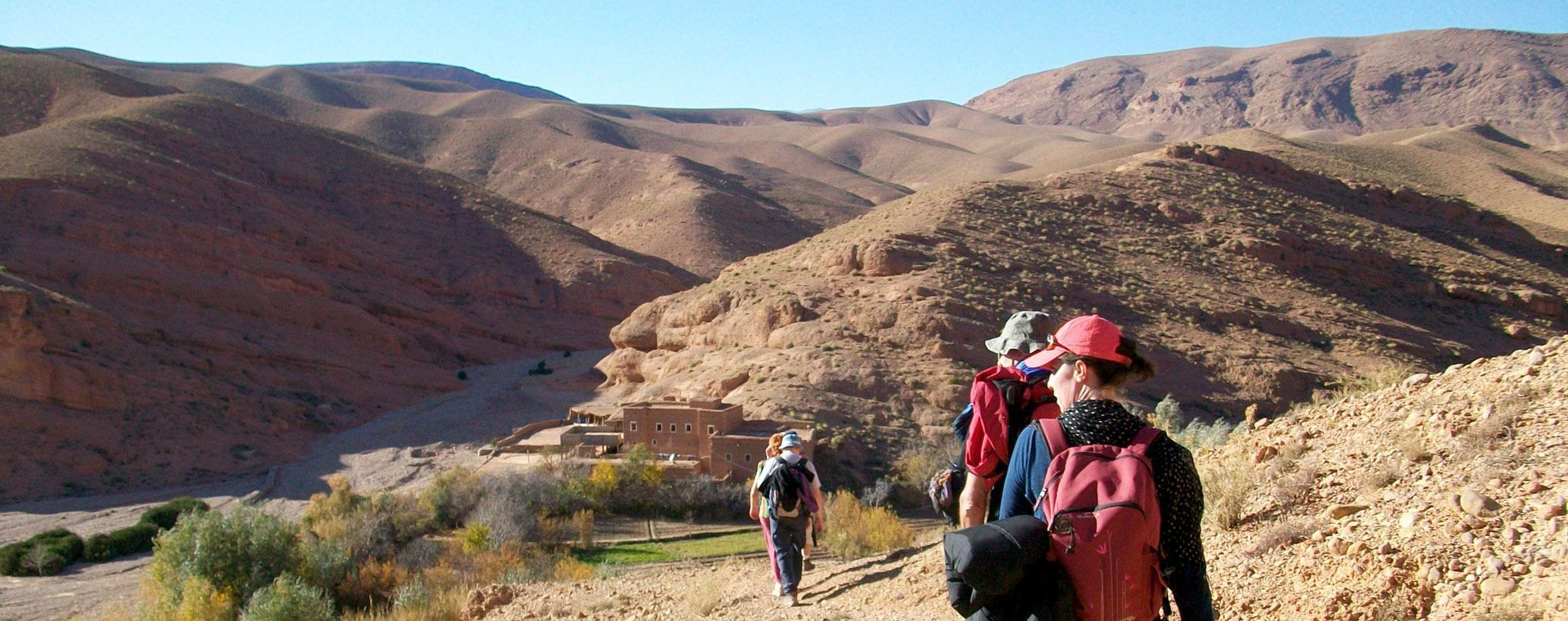 Randonneurs vers un village dans les montagnes arides - Vallée des Roses - Maroc