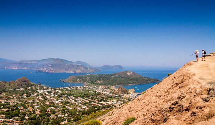 Randonneurs admirant les iles Eoliennes depuis Vulcano - Sicile Italie