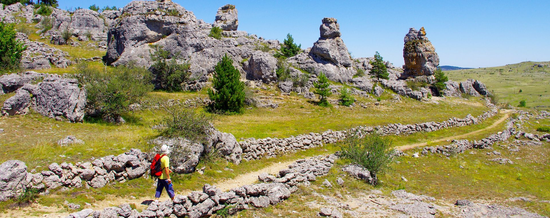 Randonneur parmi les rochers ruiniformes - Grande Traversée du Massif central - France