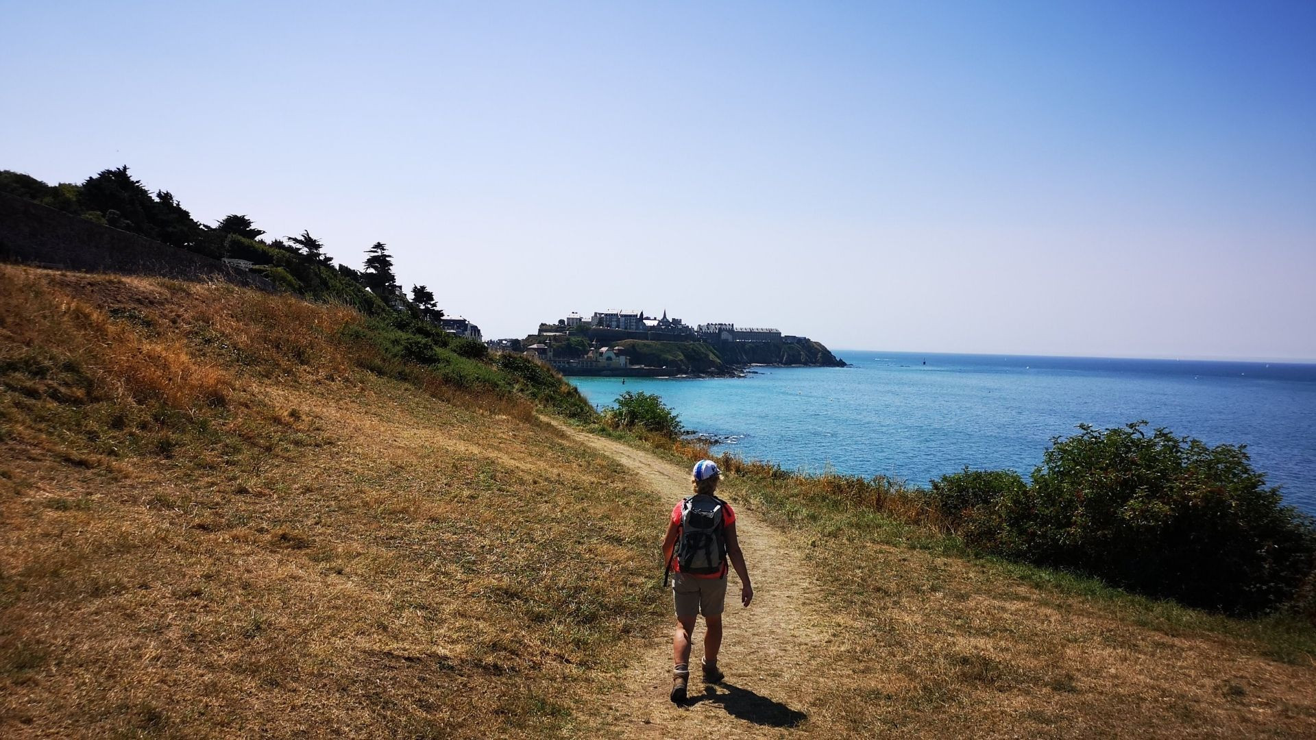Randonneur sur un sentier côtier au-dessus de la mer - Bretagne - France