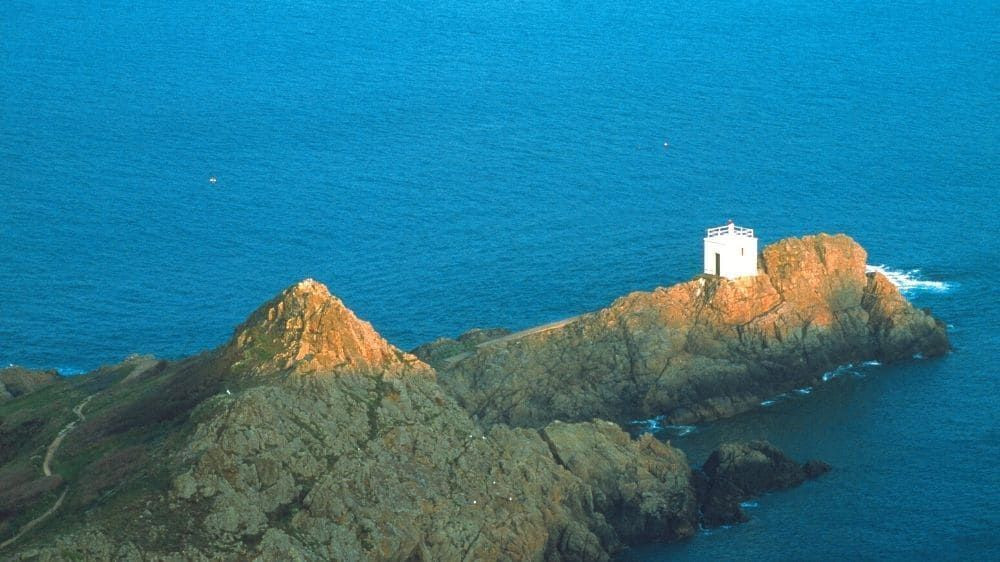 Pointe rocheuse et tour blanche au-dessus de la mer - Îles Anglo-Normandes