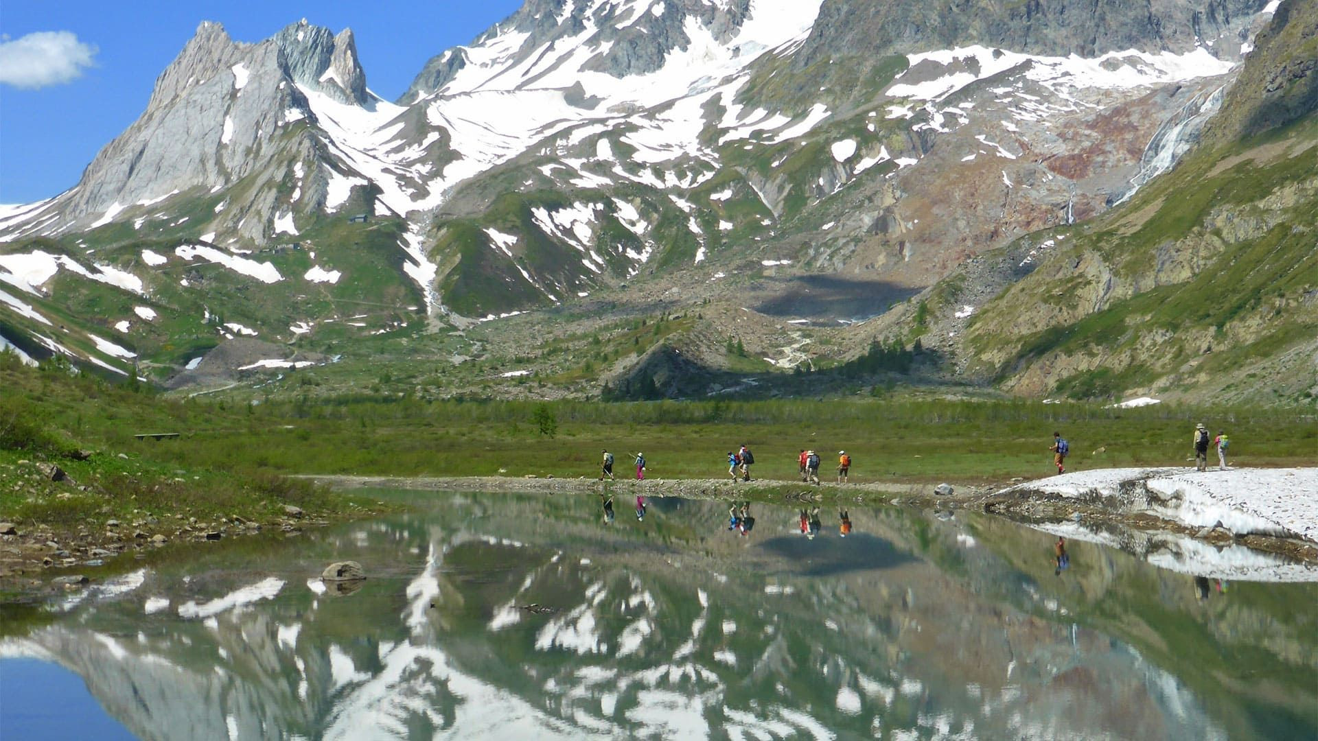 Randonneurs et reflets dans un lac face au massif du Mont-Blanc - Alpes - France
