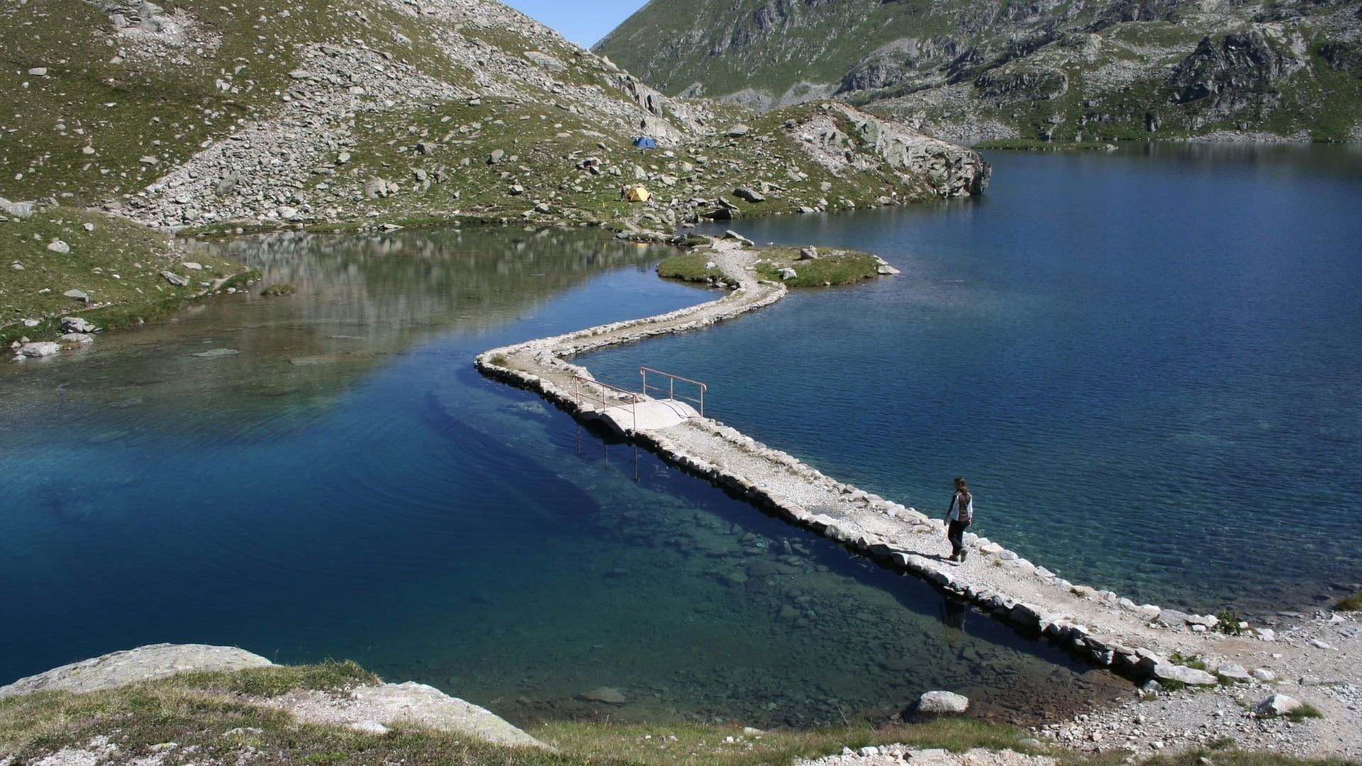 Randonneuse sur la digue d'un lac des Sept Laux - Belledonne - France