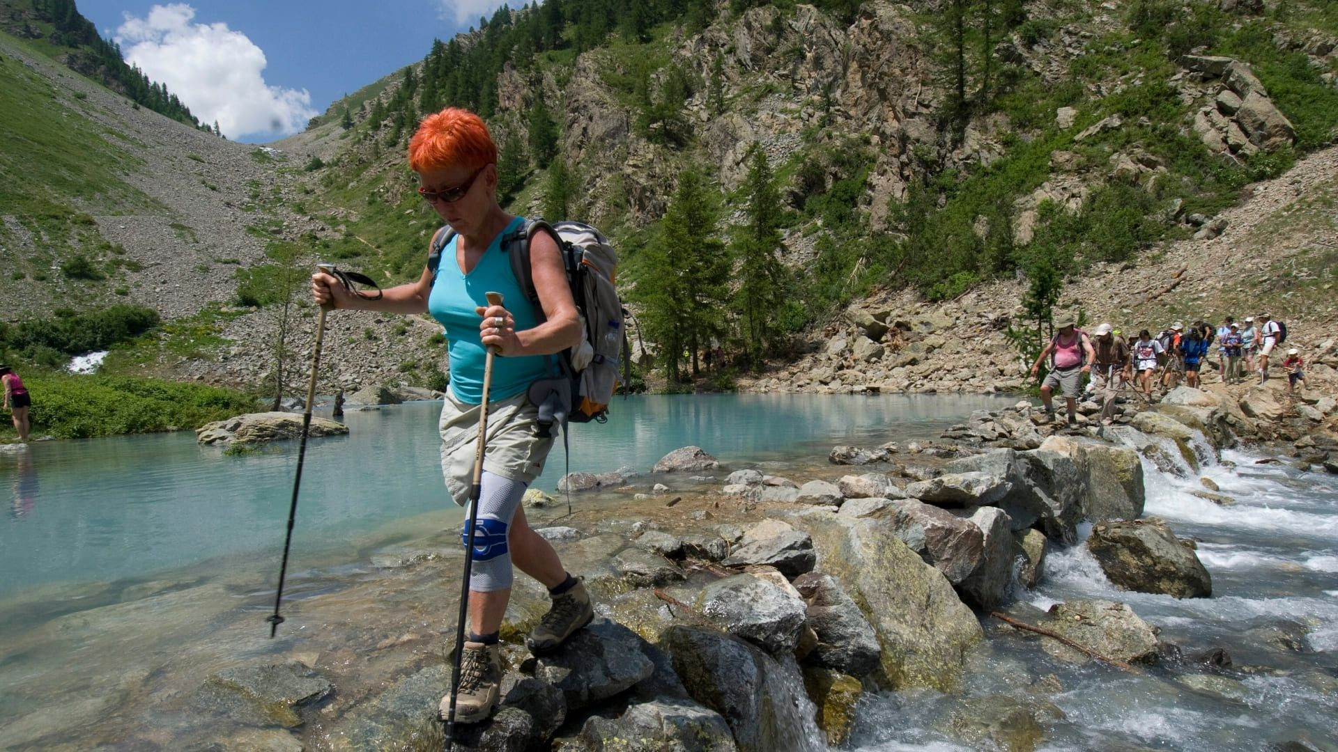 Randonneuse traversant un torrent de montagne - Alpes - France