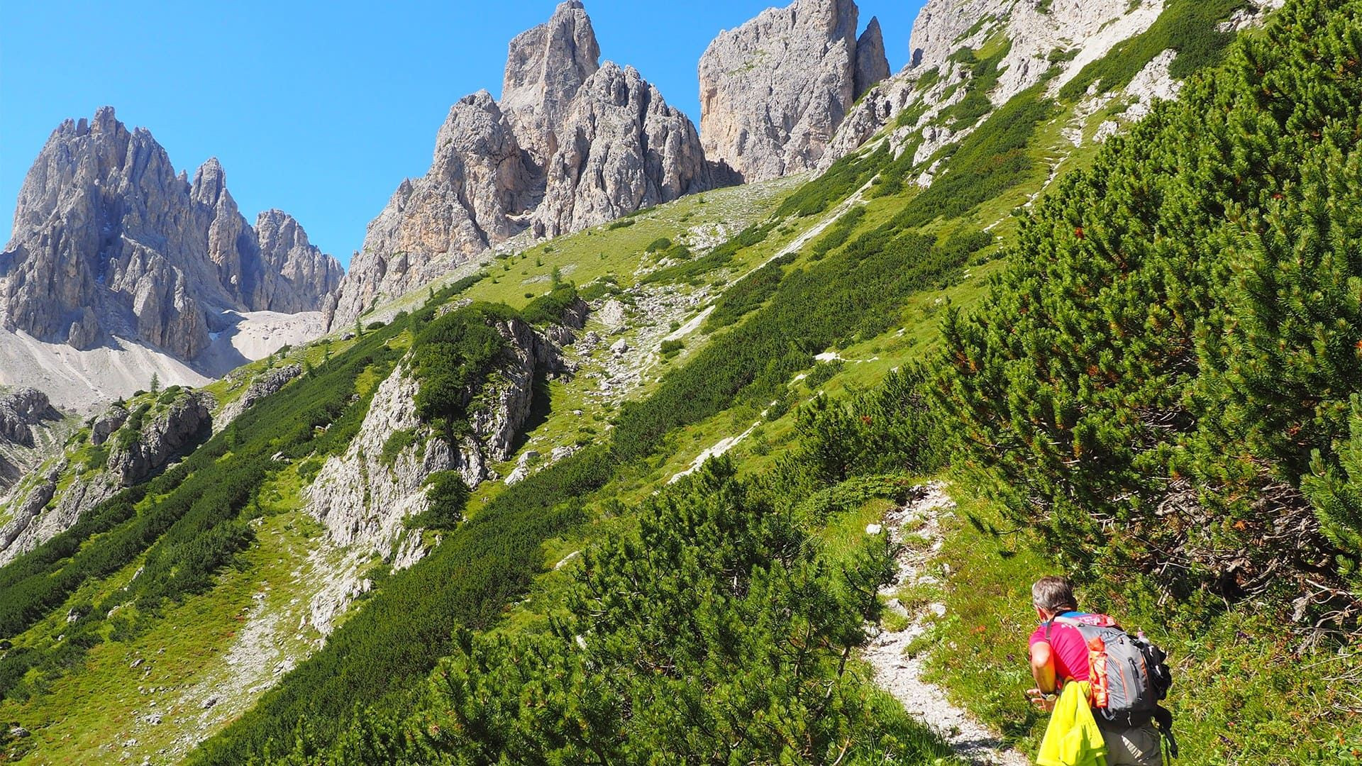 © Thomas Praire Randonneur montant vers les aiguilles rocheuses - Dolomites - Italie