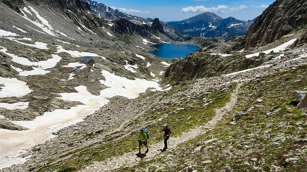 Randonneurs au-dessus d'un lac d'altitude - Mercantour - Alpes - France