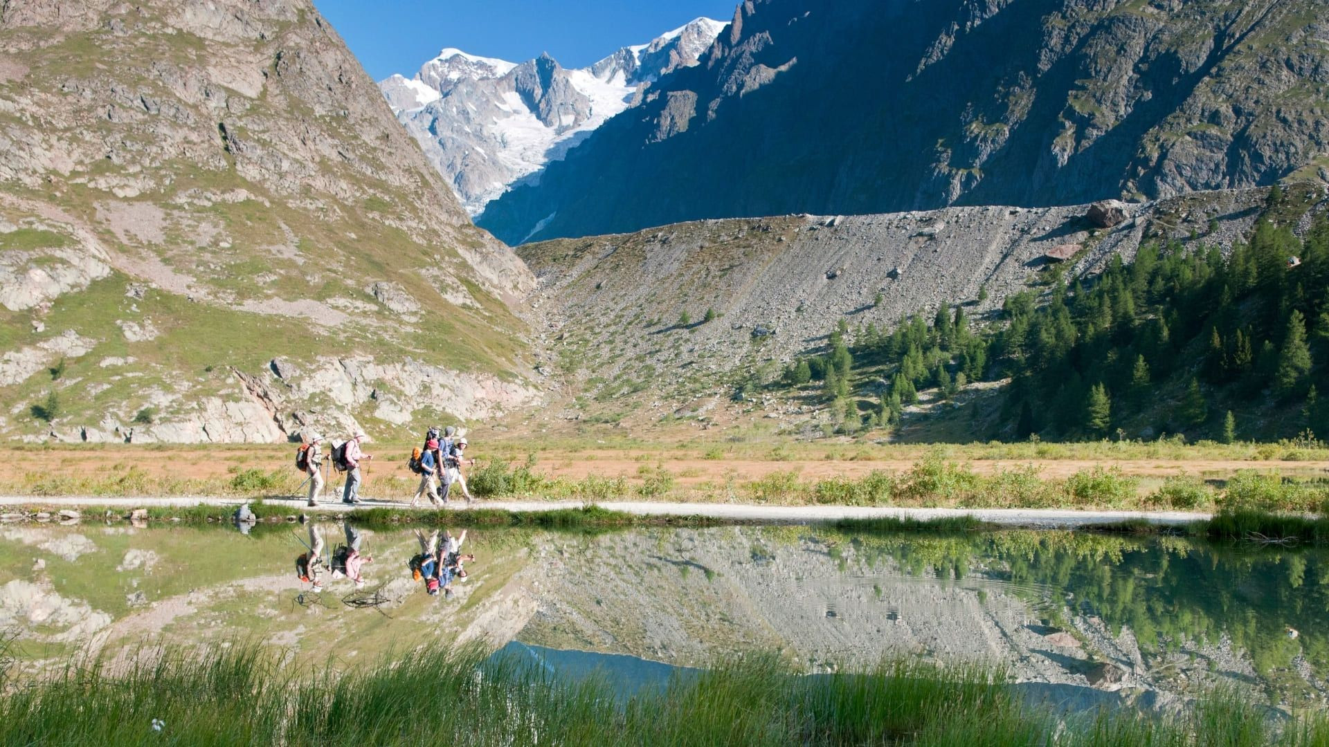 Randonneurs au bord d'un lac glaciaire dans les Alpes - France