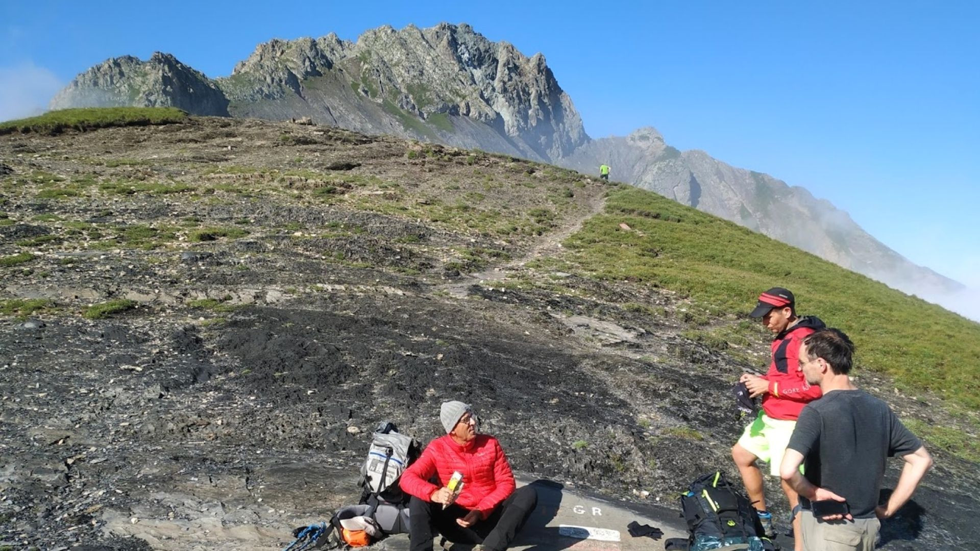 © Laura Kankaanpää Pause des randonneurs sur un col rocheux - Trek Grenoble-Briançon - Alpes, France