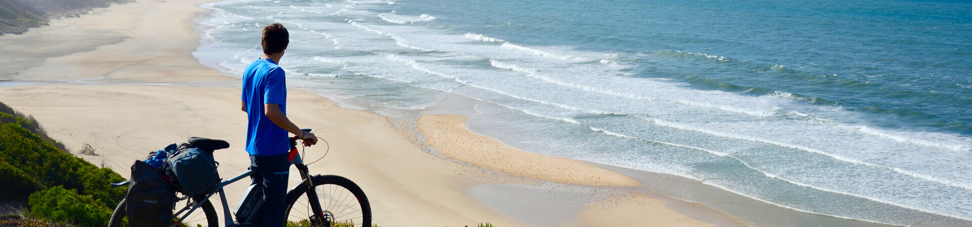 Cycliste face à la plage de Paredes da Vitória - Estrémadure - Portugal