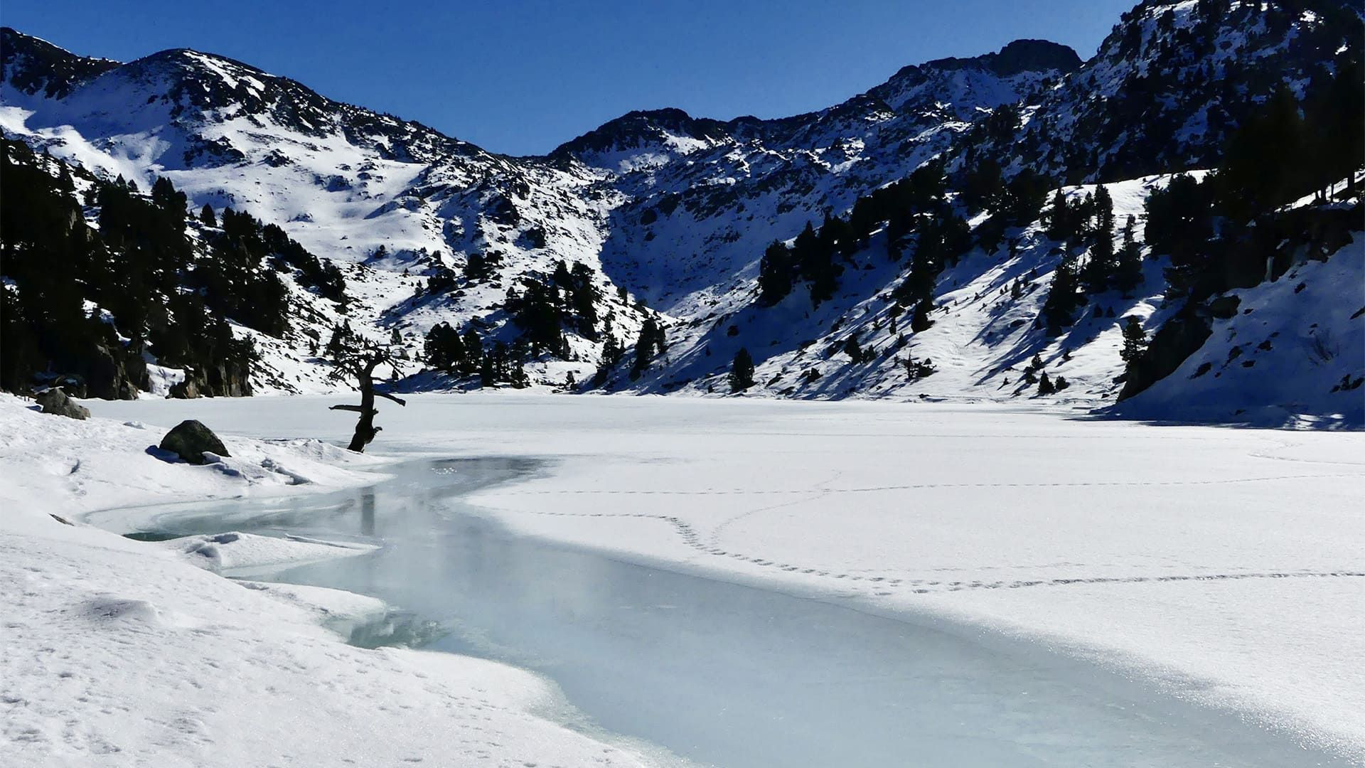 Lac de montagne gelé sous les sommets enneigés - Pyrénées - France