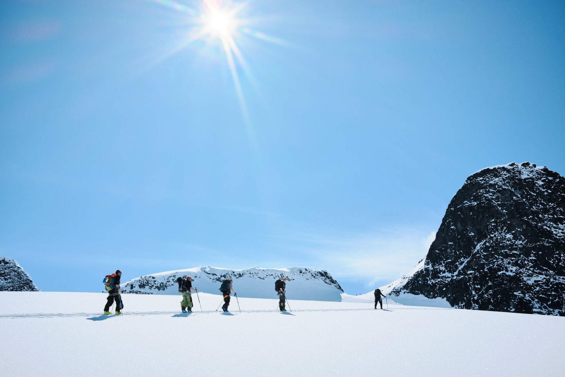 Groupe de skieurs de randonnée à la montée sur un champ de neige - Scandinavie